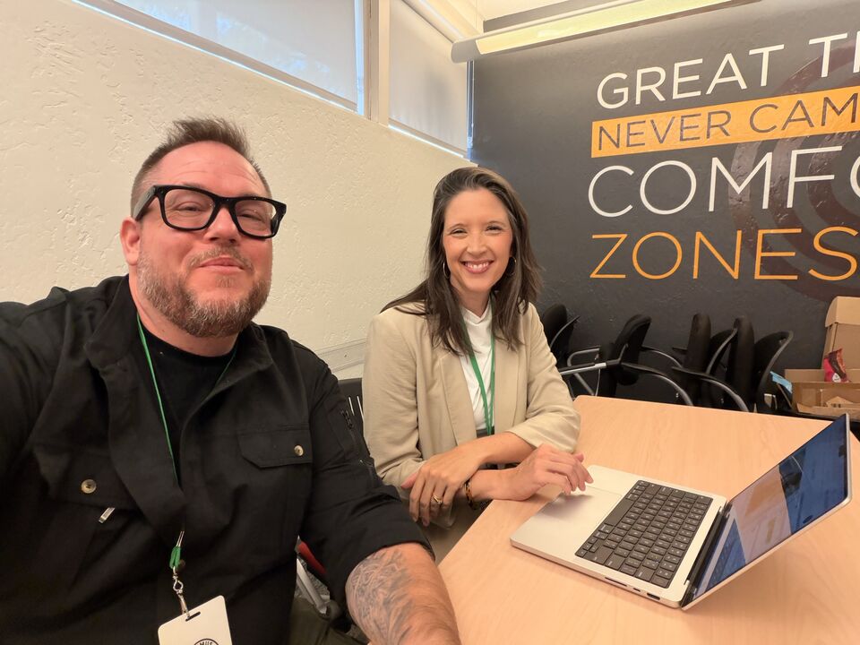 JJ and a guest at a work table with a laptop