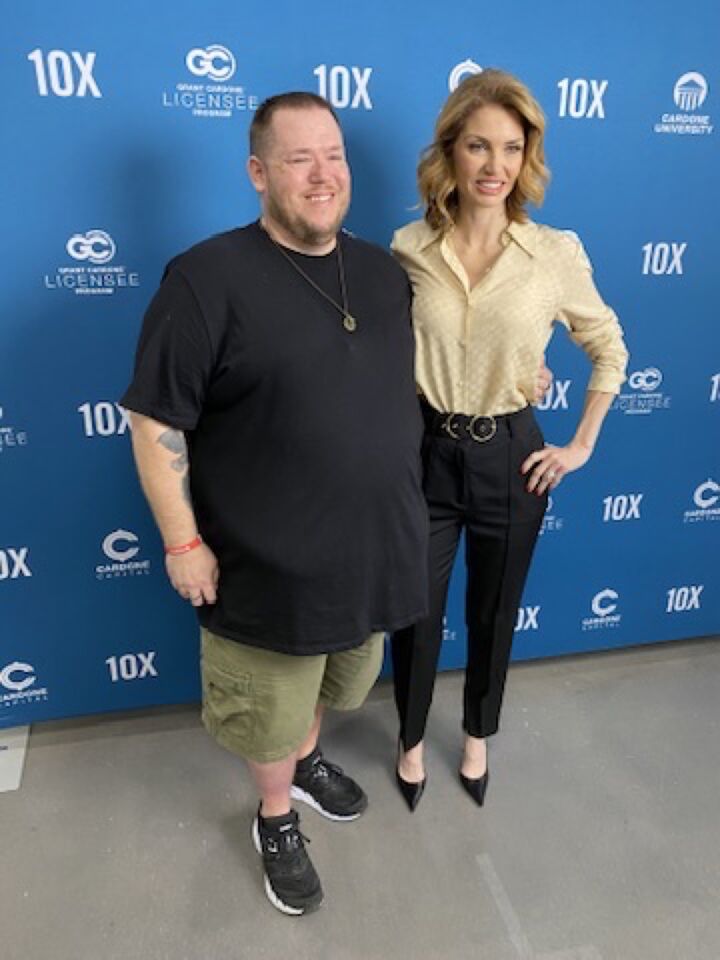 JJ and a guest in front of an event backdrop