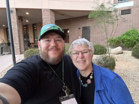 JJ and a guest outdoors at a conference