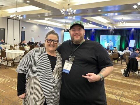 JJ and a guest in a conference ballroom